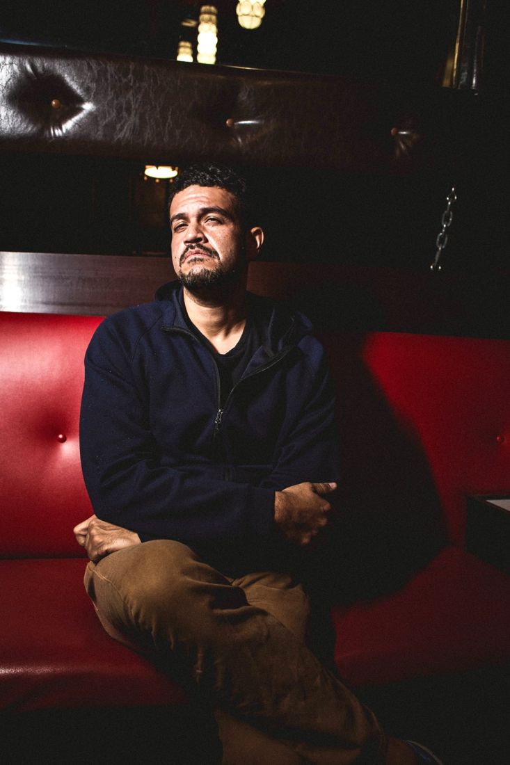 Jason seated on a red leather couch